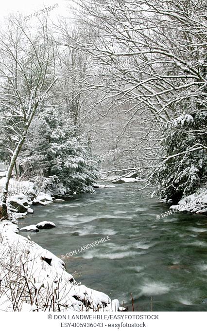 River running through snow covered trees, Stowe, Vermont, USA