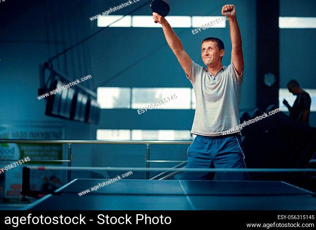 Man wins table tennis match, ping pong player. Sportsman playing table-tennis indoors, sport game with racket, active healthy lifestyle