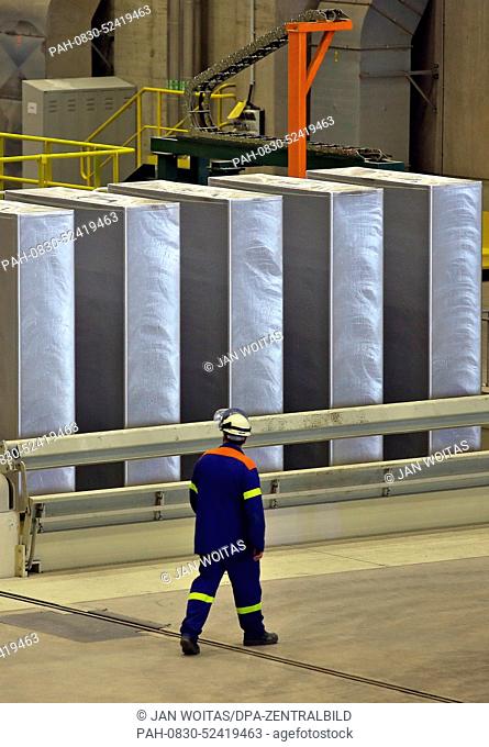 A Novelis employee walks past newly cast, 25-ton heavy aluminium ingots in Nachterstedt, Germany, 01 October 2014. According to Novelis