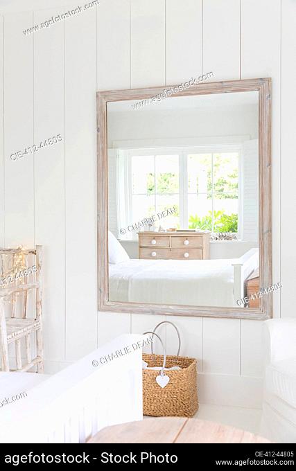 Reflection in mirror of white home showcase bedroom