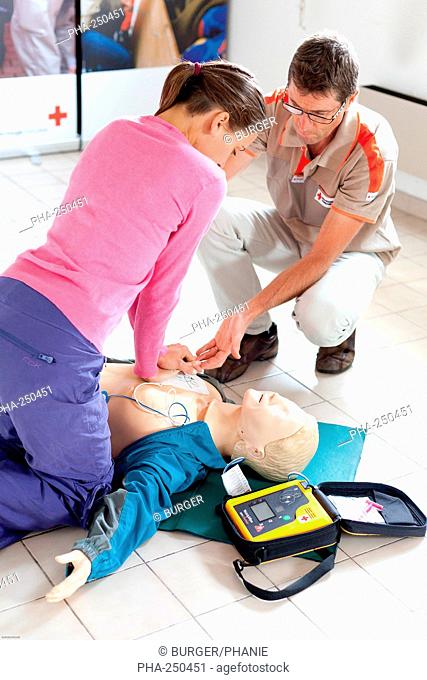 First aid training courses given by the French Red Cross. Portable semi-automatic heart defibrillator used on a mannequin