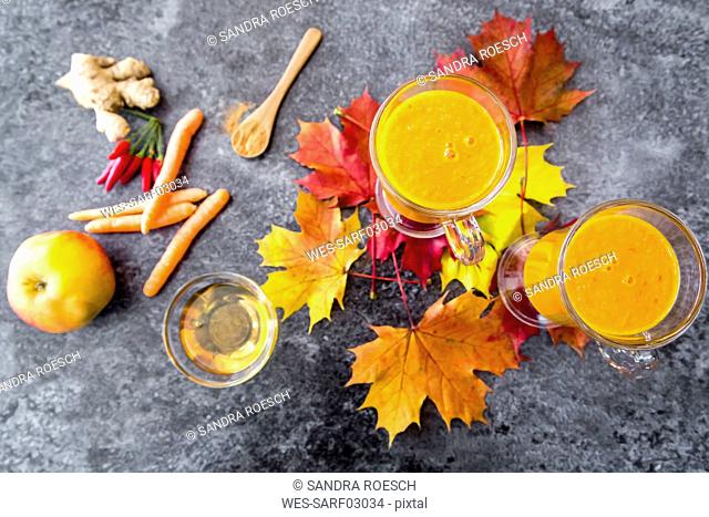Two glasses of pumpkin smoothie and ingredients
