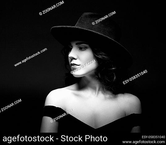 Profile portrait of a beautiful elegant brunette lady woman with long hair wearing a black hat