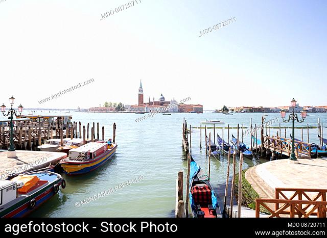 Gondolas moored near Piazza San Marco. In the background, the island of San Giorgio Maggiore. Venice (Italy), June 1st, 2021