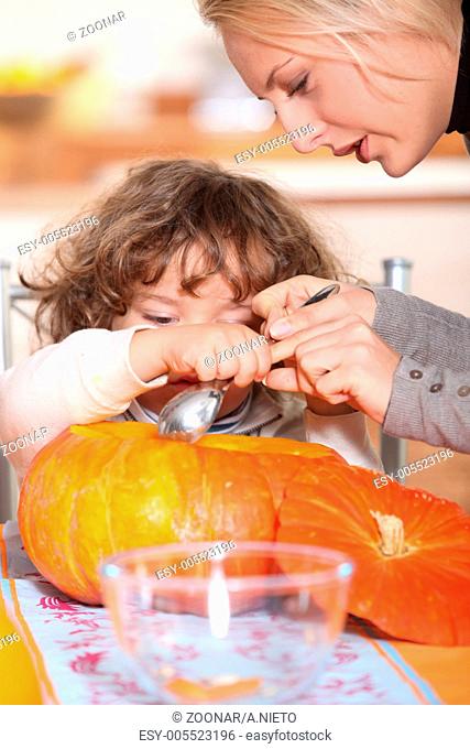 mother and her child emptying a pumpkin
