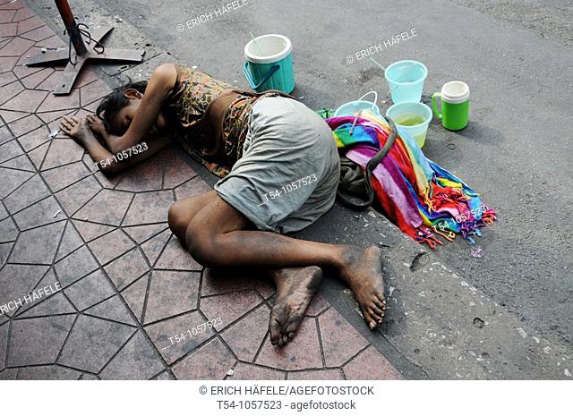 Poor Beggar sleeping on a Street in Bangkok , Thailand
