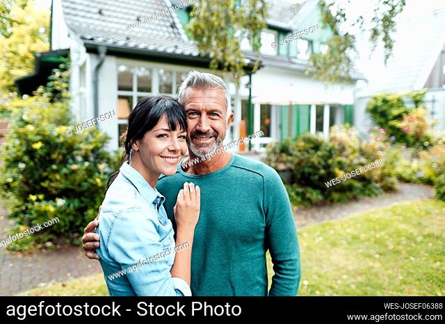 Smiling mature couple in backyard
