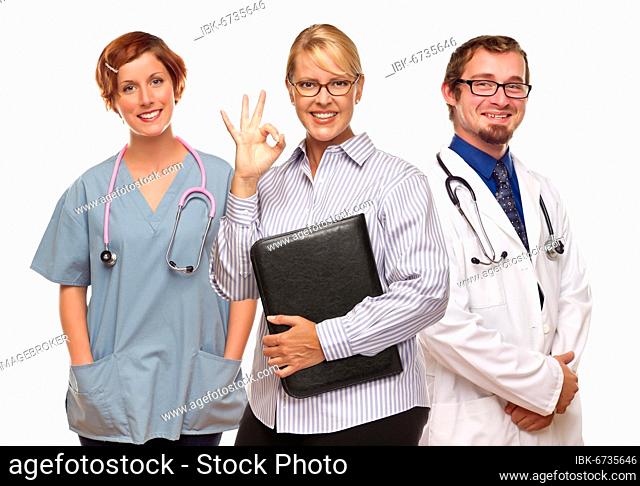 Businesswoman making okay hand sign with two doctors or nurses isolated on a white background