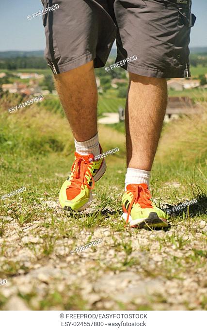 Man walking on sidewalk, sport shoes closeup, France