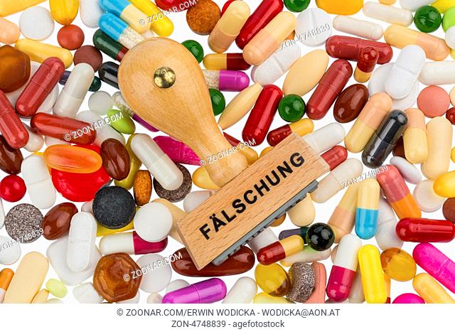 Stempel auf bunten Tabletten, Symbolfoto für Medikamentenfälschung und Produktpiraterie