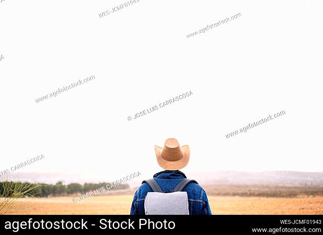 Man with hat looking at view during sunny day
