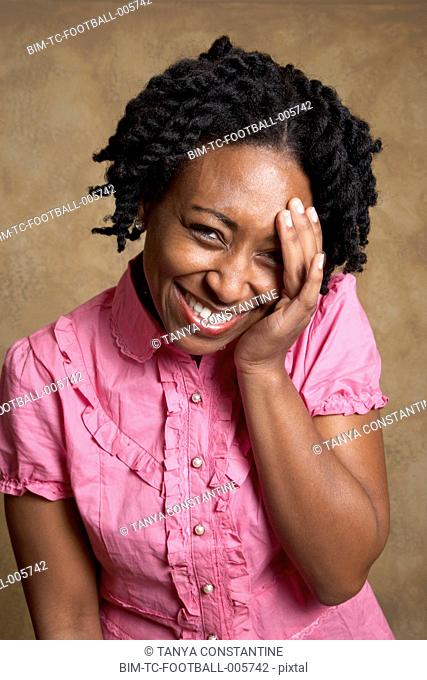 African woman laughing with hand on face
