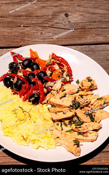Spicy Chicken Diablo with cilantro, olives, peppers, garlic and onion served over saffron yellow rice