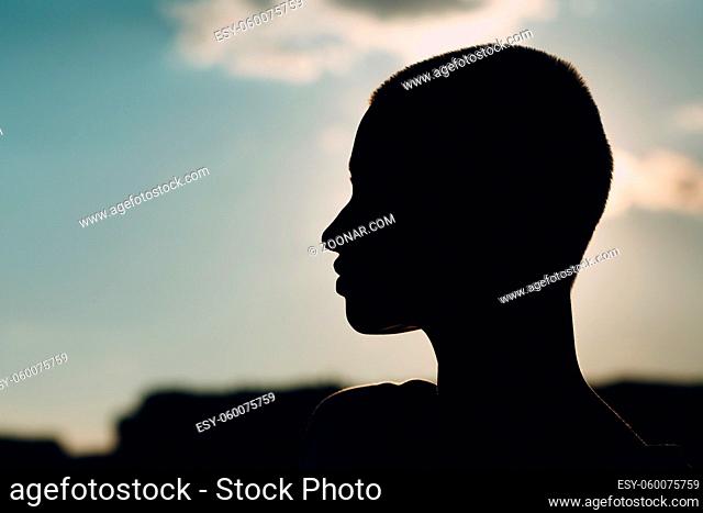 Portrait profile silhouette of young smiling millenial european short haired woman. Beautiful happy blonde girl outdoor. Summer fashion female clothing