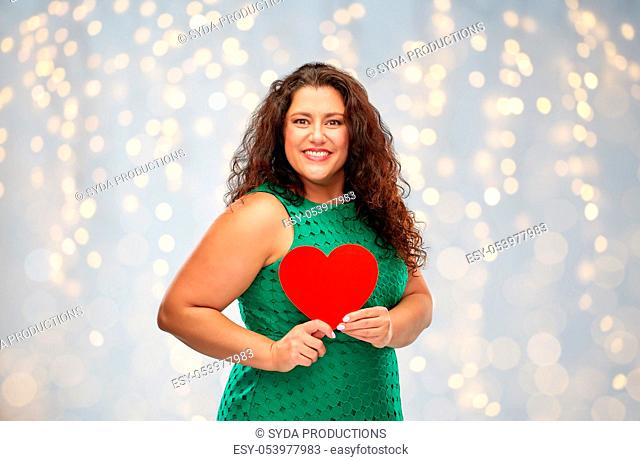 happy woman holding red heart over lights