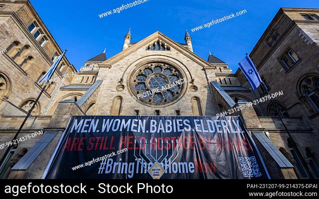 07 December 2023, North Rhine-Westphalia, Cologne: A banner with the inscription ""Men. Women. Babies. Elderly. are still held hostage by Hamas"" stands in...