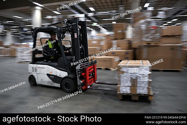PRODUCTION - 07 December 2023, Hesse, Frankfurt/Main: An employee drives a forklift truck in the DB Schenker air freight hall in Cargo City South at Frankfurt...