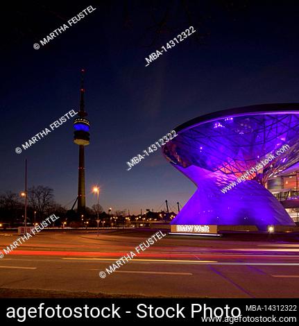 BMW World with Olympic Tower, illuminated in Ukrainian national colors blue and yellow on the occasion of war in Ukraine, Munich, Bavaria, Germany, Europe