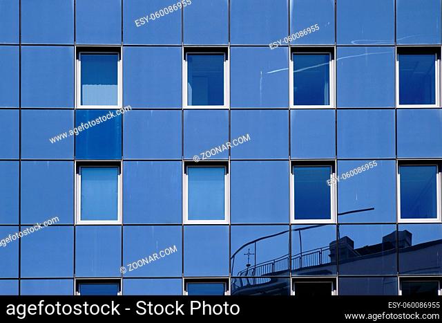 Die Reflektion von Gebäuden in der modernen Spiegelfassade eines Bürohauses und Wohnhauses