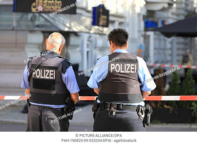 20 August 2019, Saxony-Anhalt, Magdeburg: Policemen are standing in front of a restaurant in the state capital. At least two people were injured during the...