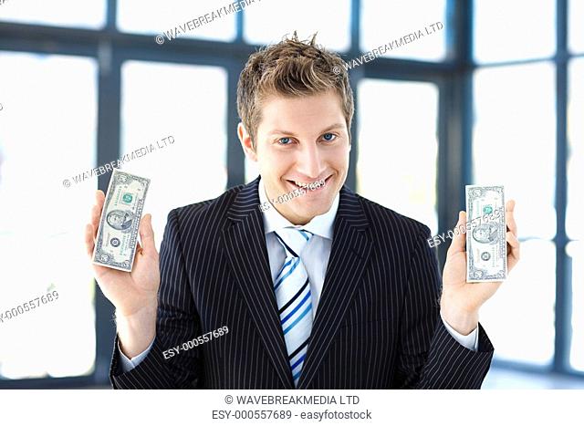 Young businessman holding money in office