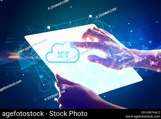 Hand holdig futuristic tablet with ICT inscription, modern technology concept