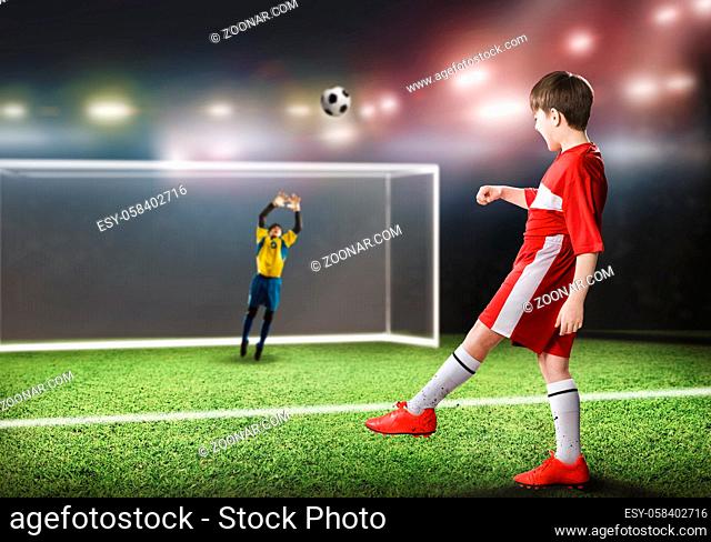 Kid boy football player on stadium kicking ball to gates