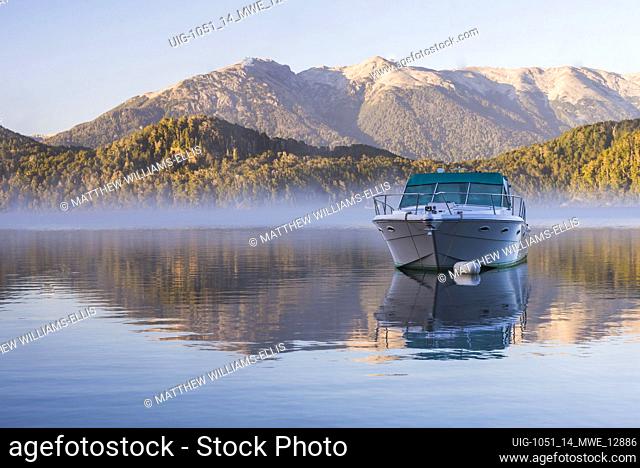 Sped boat on a misty Lake Nahuel Huapi at sunrise, Villa la Angostura, Neuquen, Patagonia, Argentina