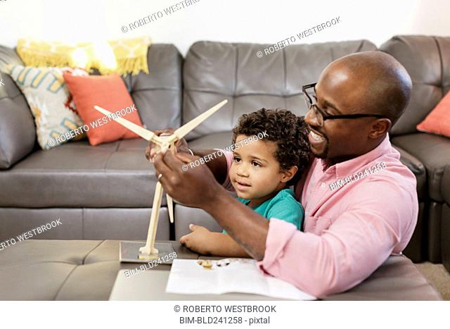 Father and son building model windmill in livingroom