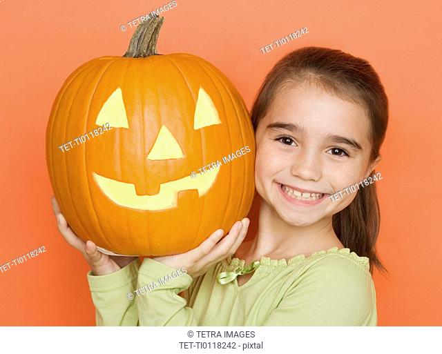 Smiling girl holding a jack o lantern