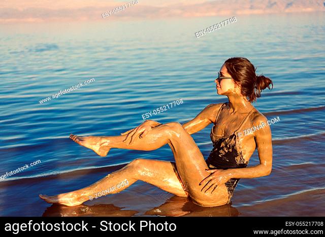 A young woman enjoying the natural mineral mud sourced from the dead sea, Israel