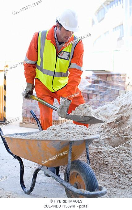 Worker shoveling concrete on site
