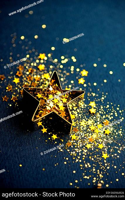 Sparkling star shaped decor on deep blue background as a Christmas card concept