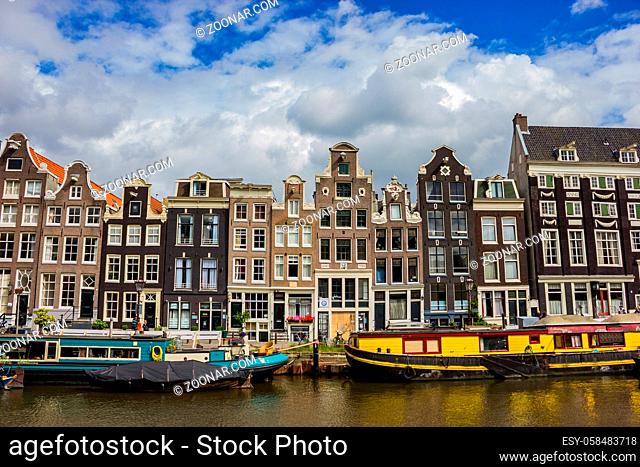 A picture of a group of buildings on the margin of a canal, in Amsterdam