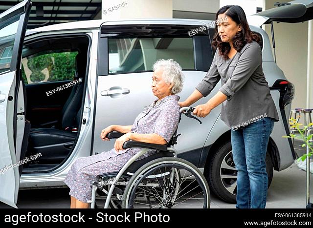 Help and support asian senior or elderly old lady woman patient sitting on wheelchair prepare get to her car, healthy strong medical concept