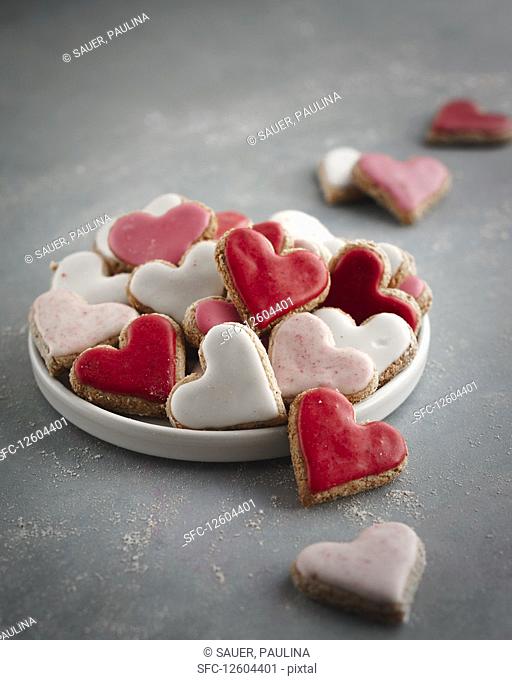 Pink, red and white heart-shaped biscuits on a plate
