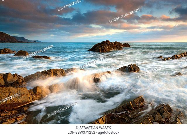 England, Devon, Hartland. Waves crashing onto the rocky shore at Hartland Quay