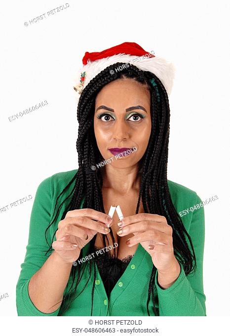 A young woman is stopping smoking and breaking the last cigarette in her hand, is a green body suit, isolated for white background
