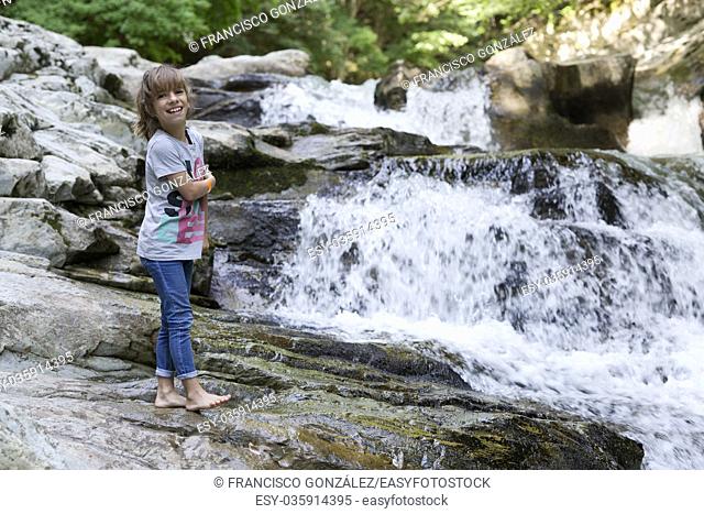 Girl next to the Waterfall of the bucket in the Selva de Irati in Navarra, Spain