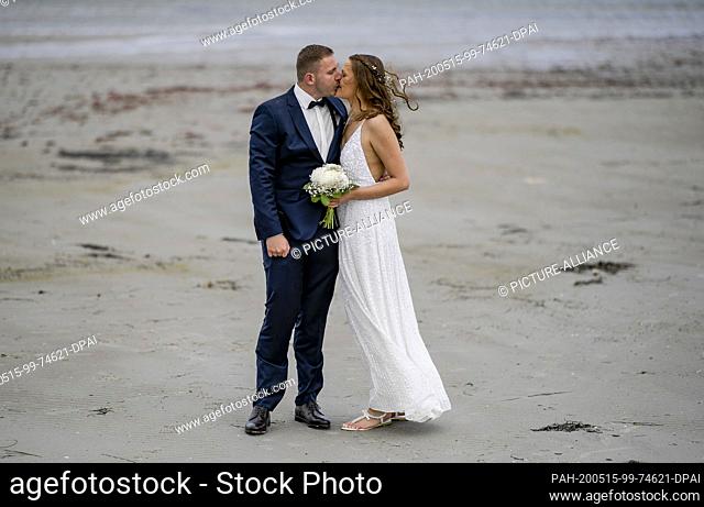 15 May 2020, Schleswig-Holstein, Stein: 23-year-old Lisann Camara and her husband Erik Camara kissed after their wedding ceremony on the beach of the Kieler...