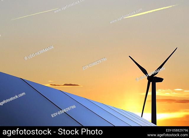 Symbol image: Solar park with wind turbines in the background