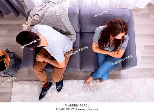 Young Depressed Couple Sitting On Sofa At Home