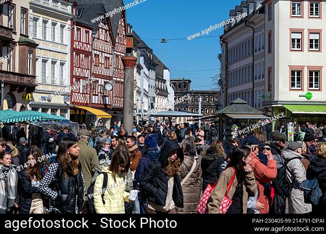 04 April 2023, Rhineland-Palatinate, Mainz: Tourist groups stand at the market cross on the main market in the city center