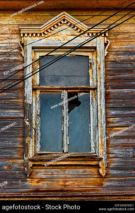 Weathered wooden window in slums with broken glass