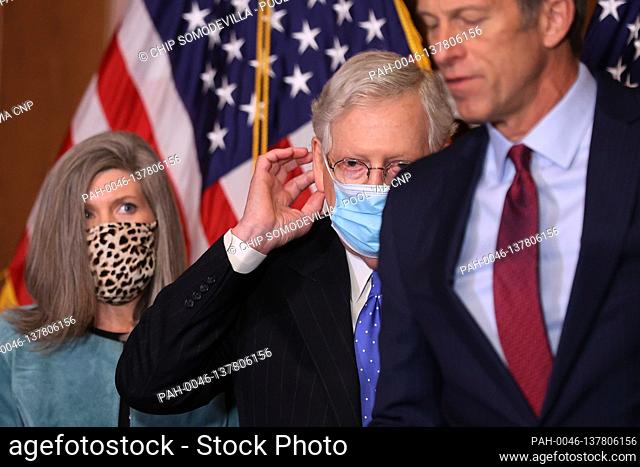 United States Senate Majority Leader Mitch McConnell (Republican of Kentucky) replaces his face mask during a news conference with US Senator Joni Ernst...