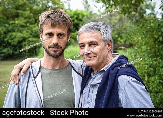 Father and son standing in garden