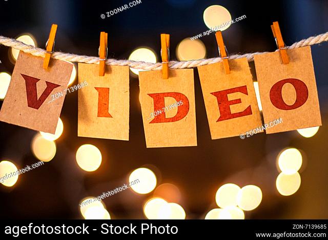 The word VIDEO printed on clothespin clipped cards in front of defocused glowing lights