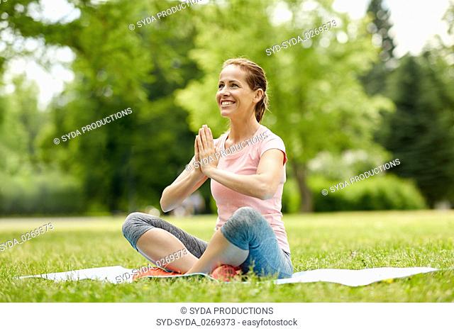 happy woman meditating in summer park