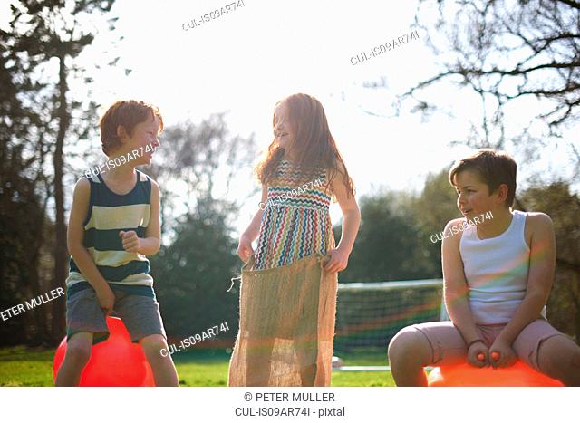 Young children on inflatable hopper and standing in sack, ready for race