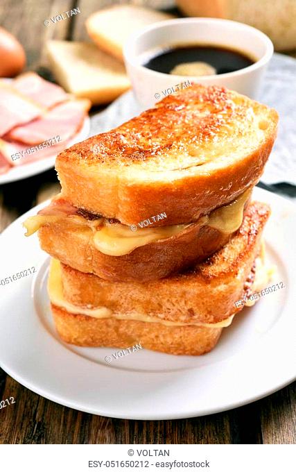Breakfast with grilled cheese sandwich and cup of coffee on wooden table